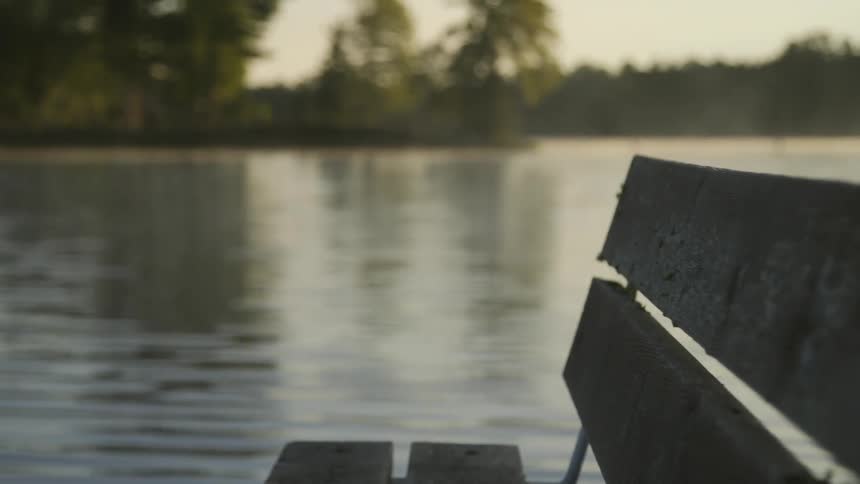 An empty bench located next to a body of water