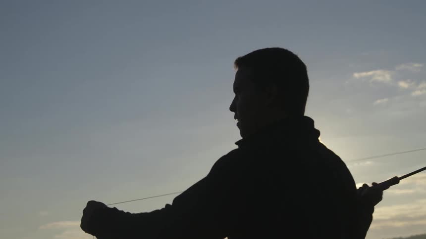 A man casts out a fishing line during the day
