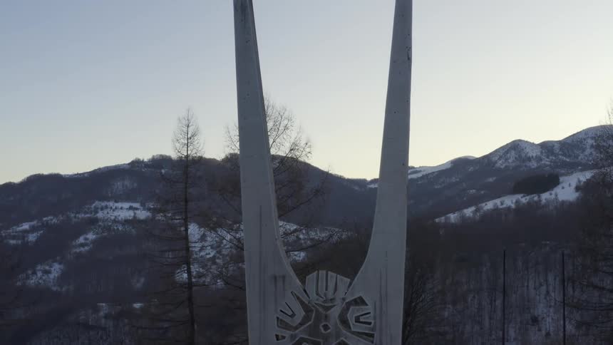 Aerial view of a monument erected on the snow covered mountains at sunset
