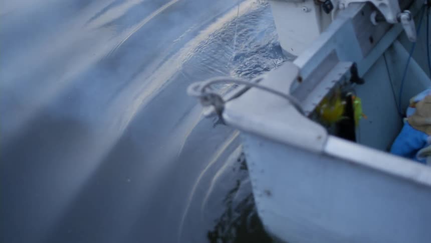 Water laps along the base and motor of a small boat