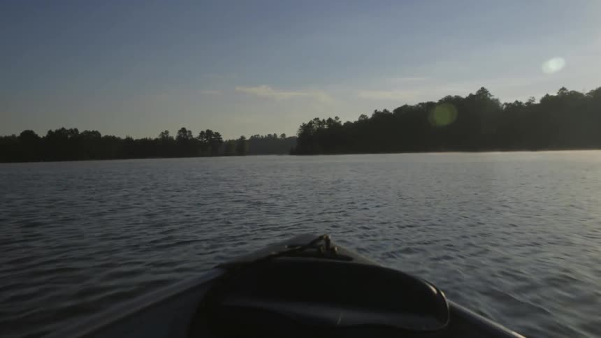 A boat is traveling fast over the water at sunset