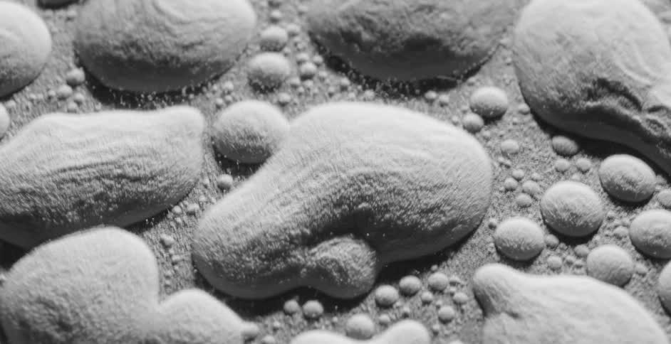 A gray powder substance vibrating around on a surface