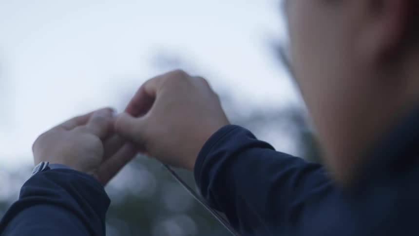 A man is putting a fishing line on a pole