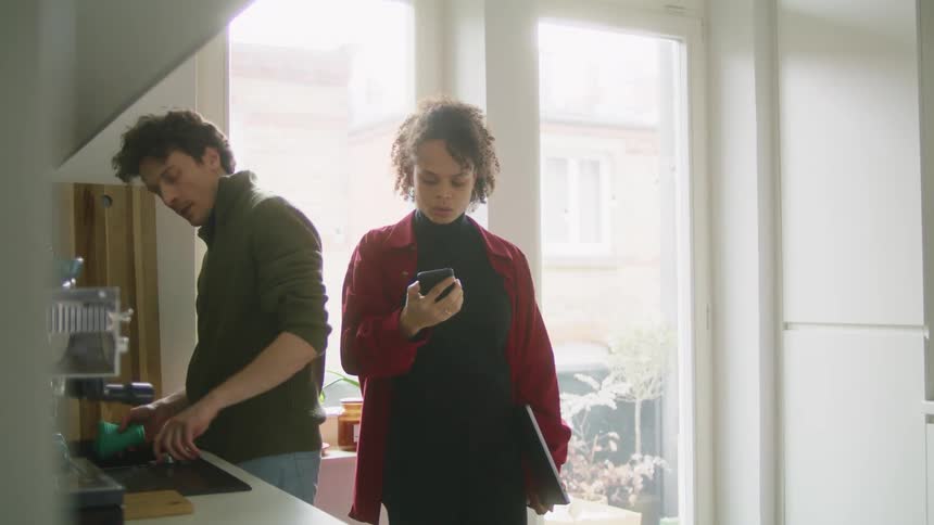 Young couple in the kitchen at home kisses at each other
