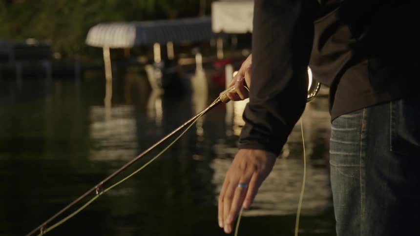 A person using a rod and reel on a dock on a chilly day