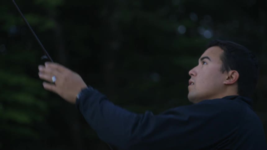 A man examines his fishing rod