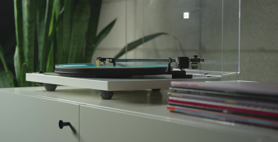 Retro turntable playing a vinyl record on a cabinet
