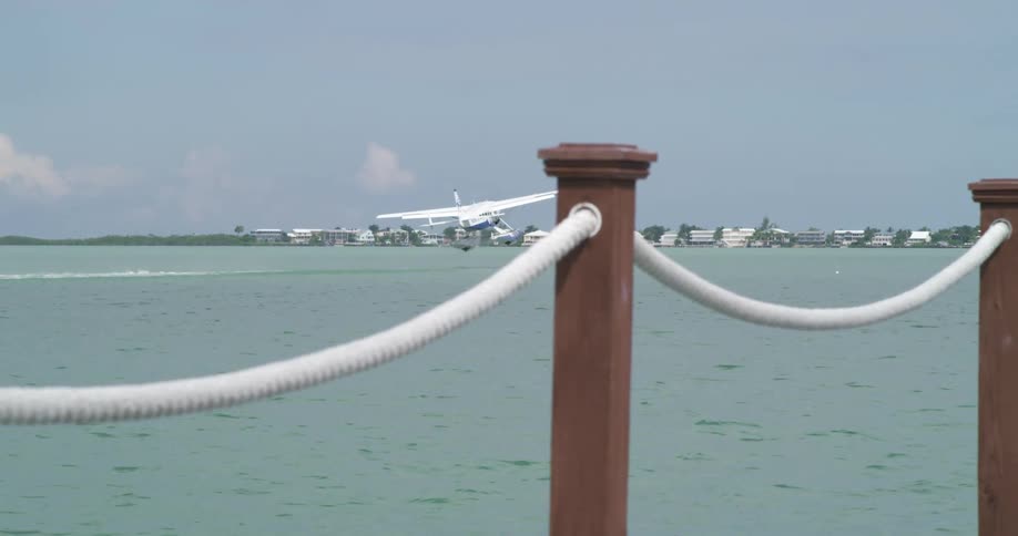 A sea plane takes off leaving a wake behind in the water