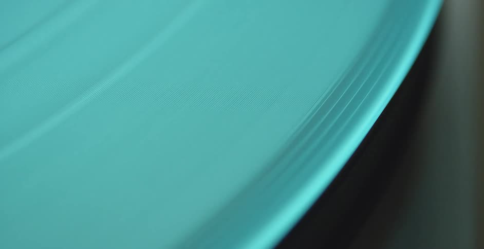 Turquoise vinyl record album spins on a turntable