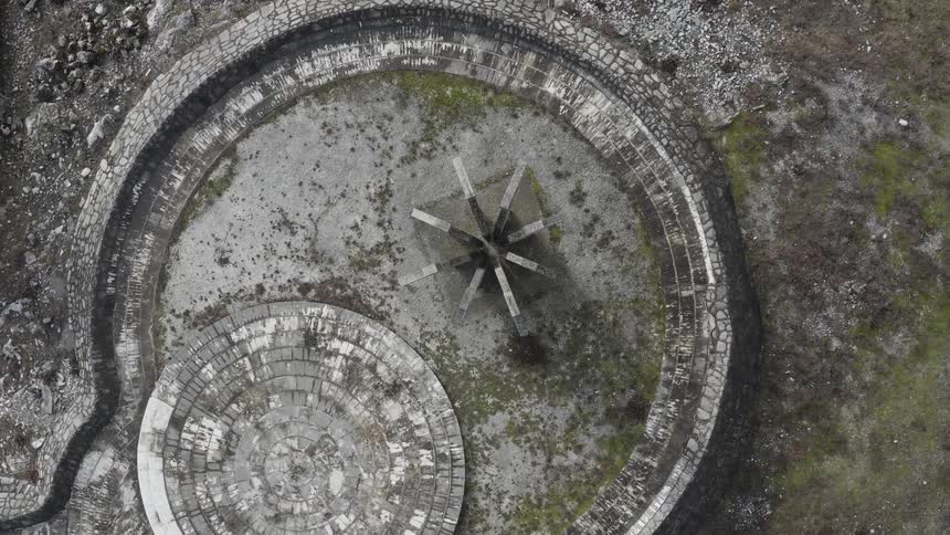 An aerial view of a ruin that is in a field