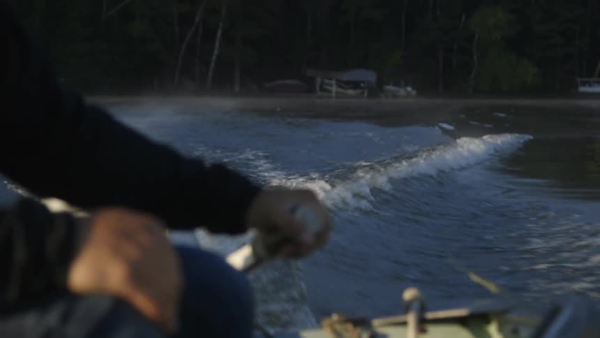 A person steering a boat away from shore