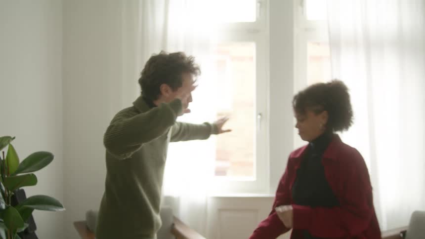 Young couple dancing on the apartment living room at daytime