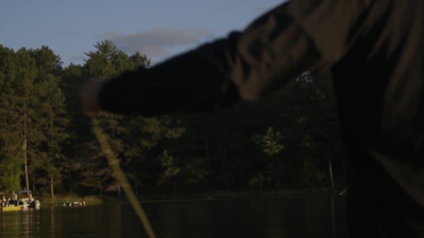 A man is fly fishing in a lake