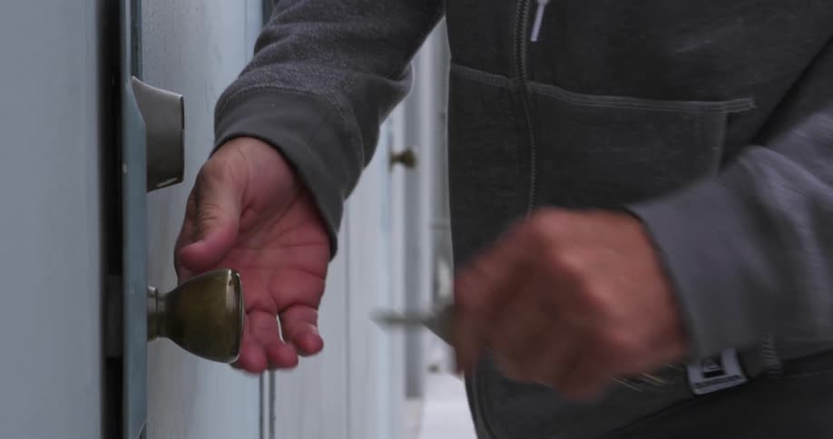A person opening up a door with a key with trees the sky and clouds in the background