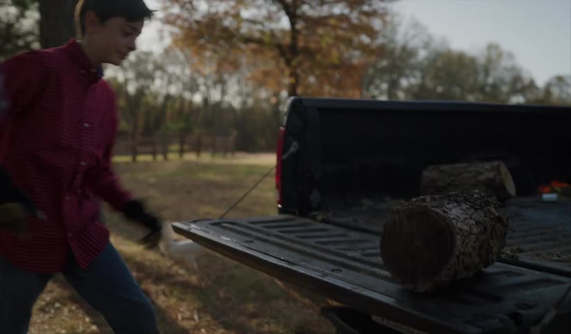 A father and son unloading logs from a truck