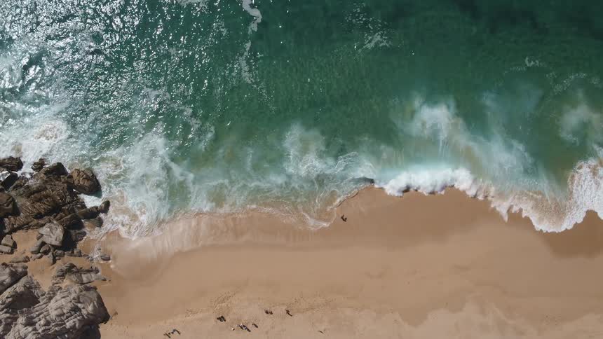 An aerial view of waves crashing on a beach