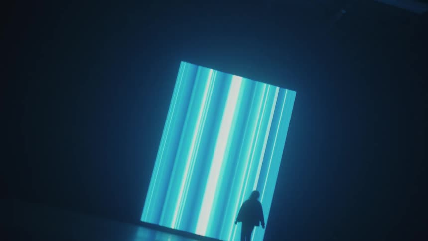 A woman walks in front of bright flashing lights