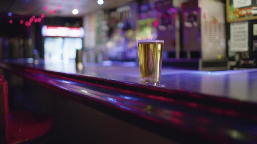 Beer glass on a vacant bar counter