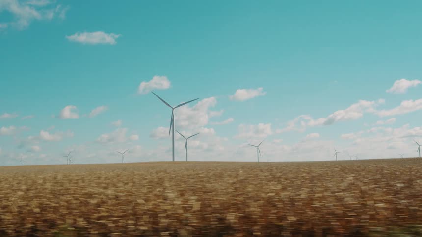 Turbines spin on a wind farm under a cloudy sky
