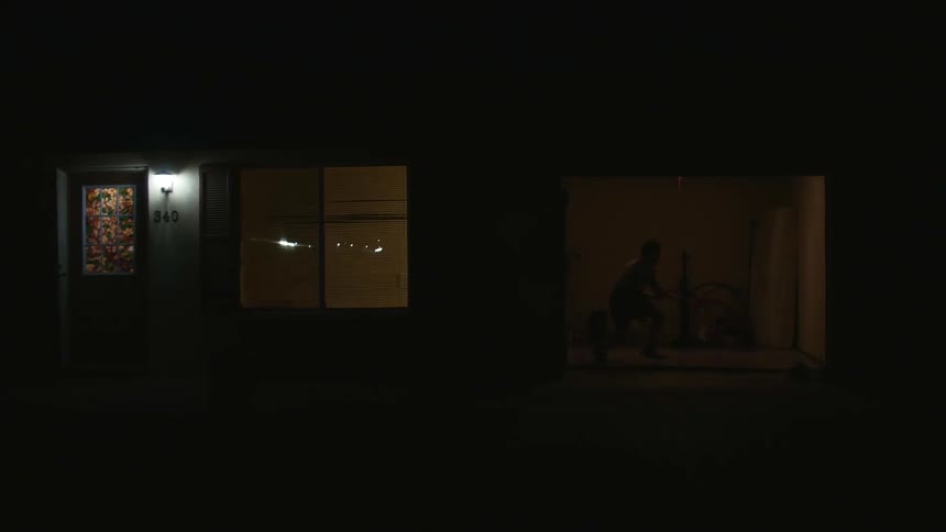 A man in a room practicing wrestling with lights flashing and a wall in the background