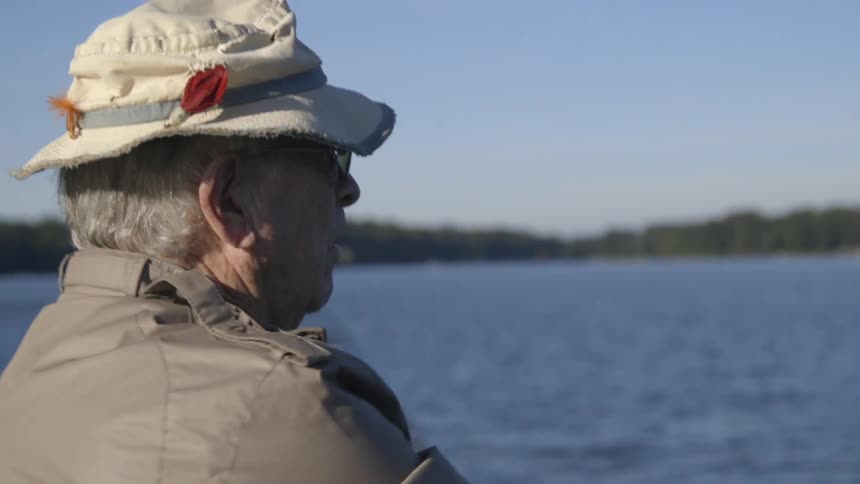 A man looks down as he fishes