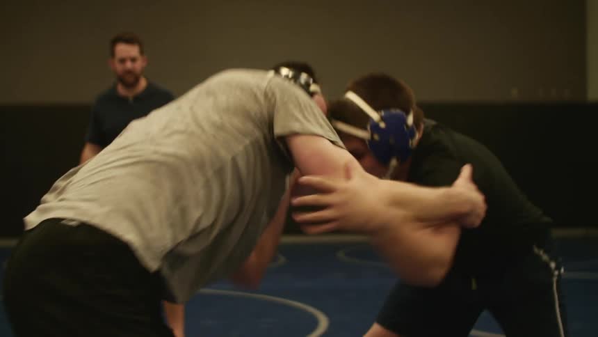 Two young strong man in a wrestling match inside a gymnasium