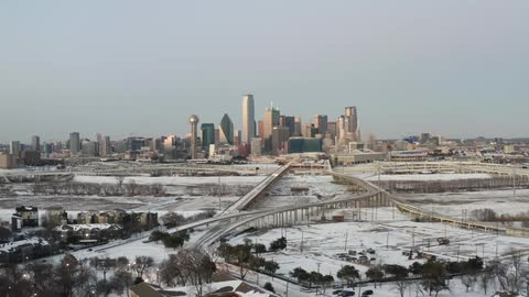 Snow covers the ground on the highway and neighborhoods near downtown