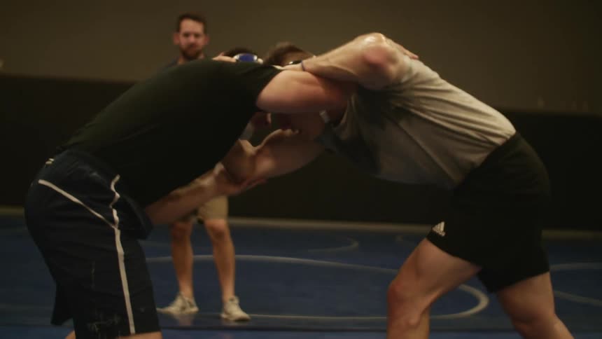 Two young strong man fighting in a wrestling match in a gymnasium