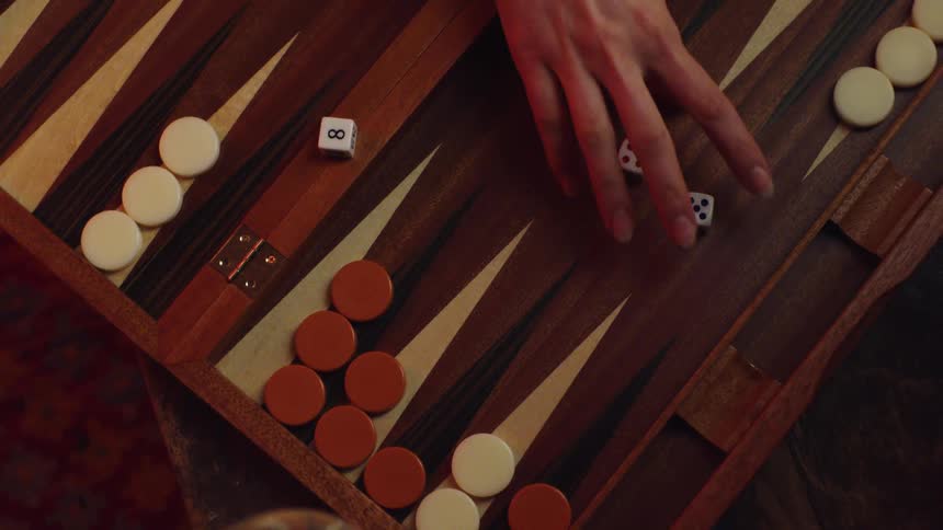 Womans hand takes dices to throw into the backgammon