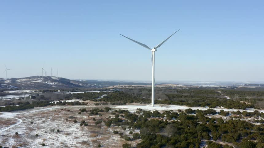 A wind turbine turns on a clear day