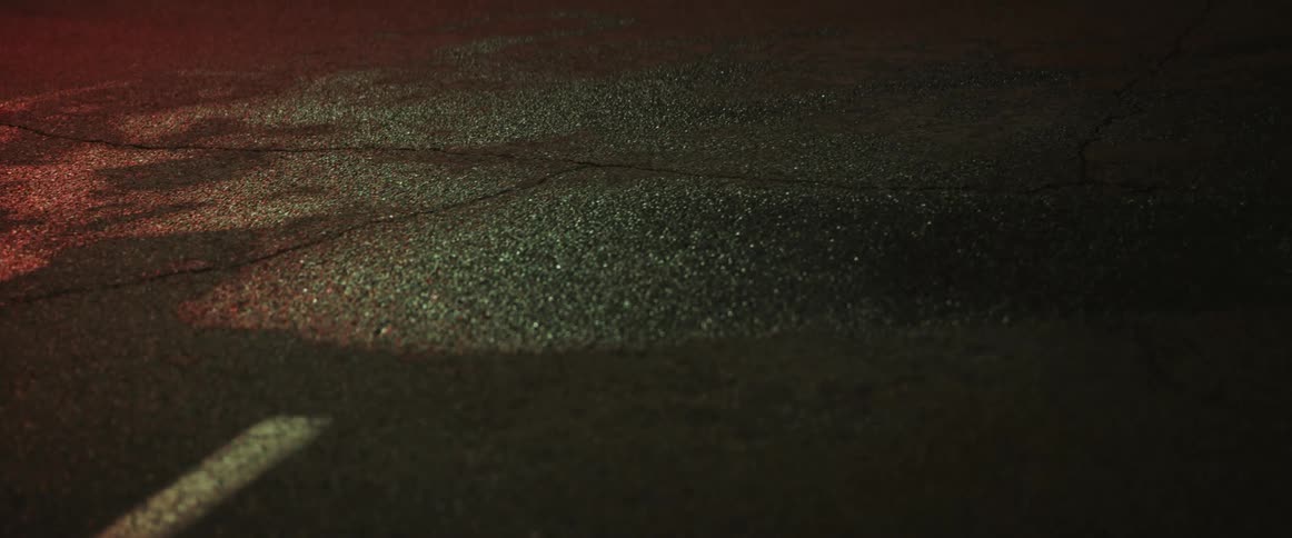 A vehicle driving on a wet street at night