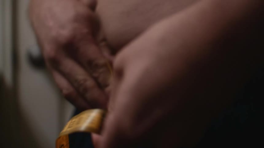 Man measuring his waist with a measuring tape