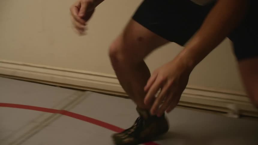 A teenage boy practices wrestling moves