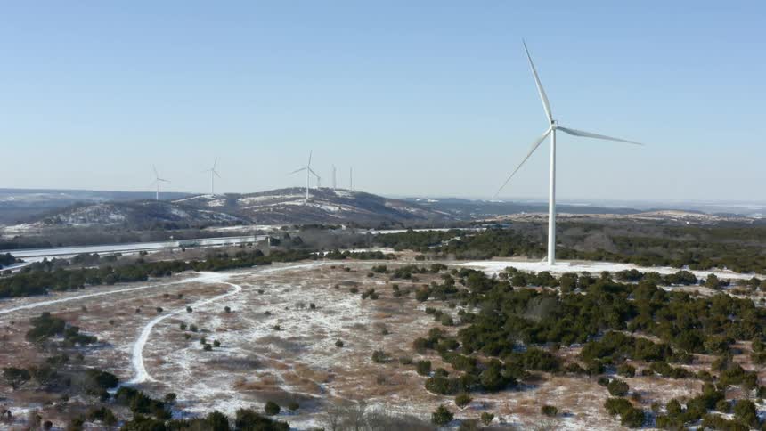 A turbine on a wind farm turns on a clear day