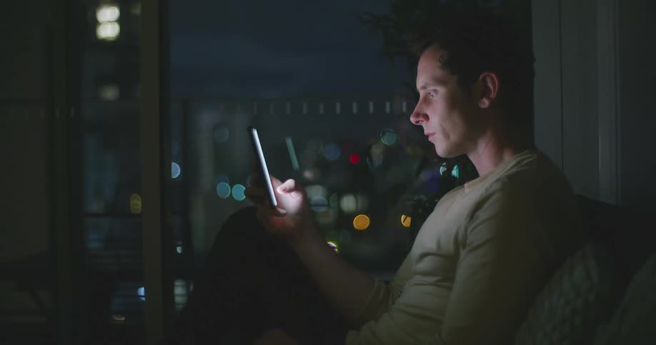 A man uses his cell phone at home