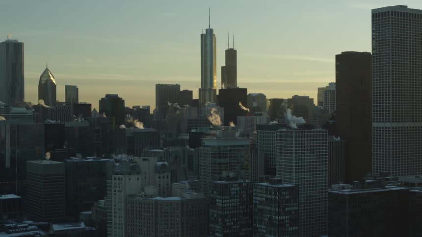 An aerial view of a downtown area with office buildings skyscrapers and cars driving