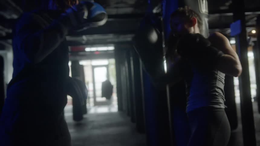 A man and woman box in the gym