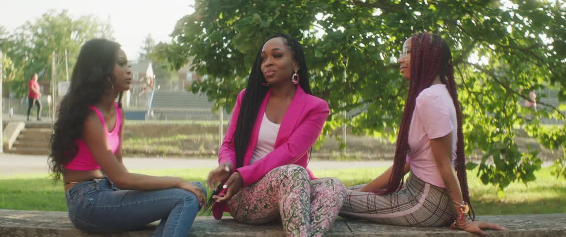 Three women sitting around outside talking to each other