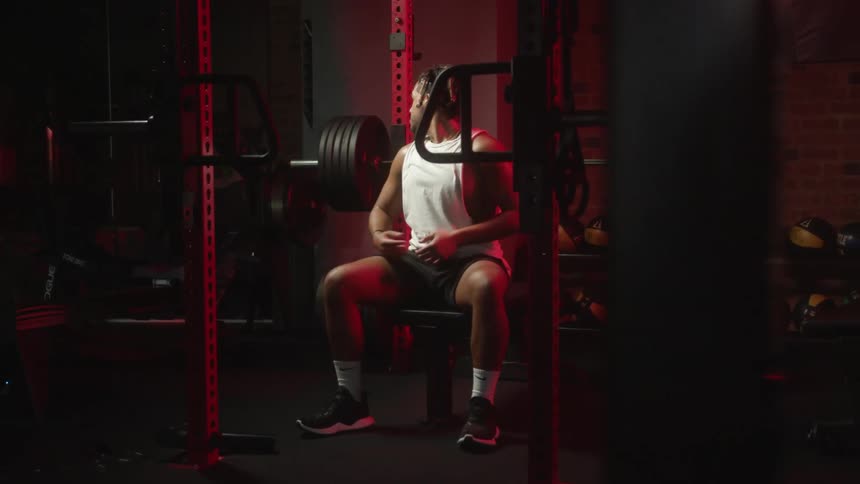 A man lies back on a bench as he gets ready to bench press