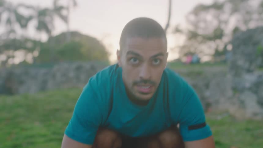 Man doing burpees on a stone bench outdoors in the tropics