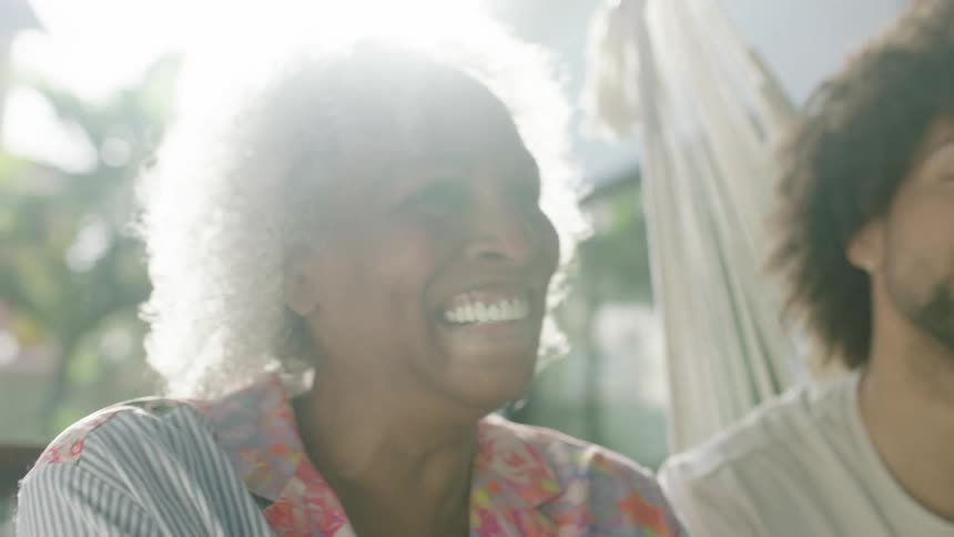 Grandmother sitting with her grandson outdoors with a flare of sunlight shining down between them