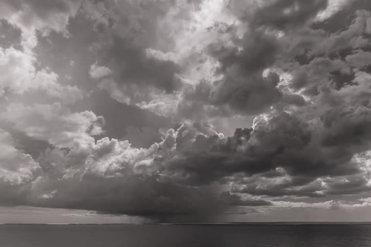Clouds flow over rippling water