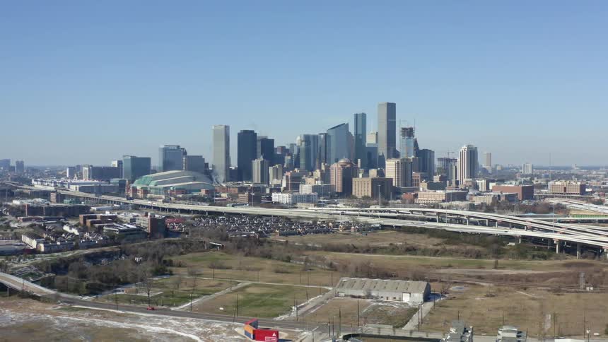 Aerial view of city skyline with tall buildings and highways