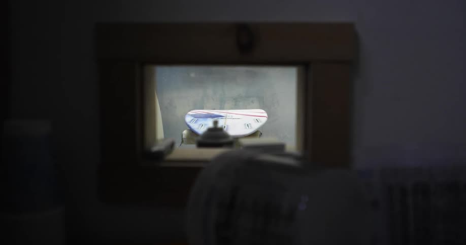 A surfboard is on the ground through the window