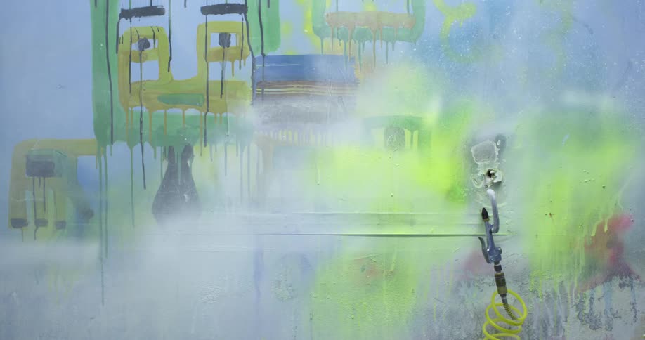 Yellow cable hangs from hook attached to spray painted wall