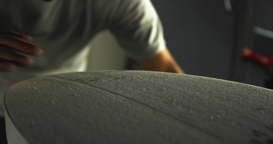 A man rubs his hand across a board after knocking it and seeing particles move on it