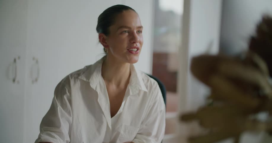 Woman working at the office greets people on a video call on the computer