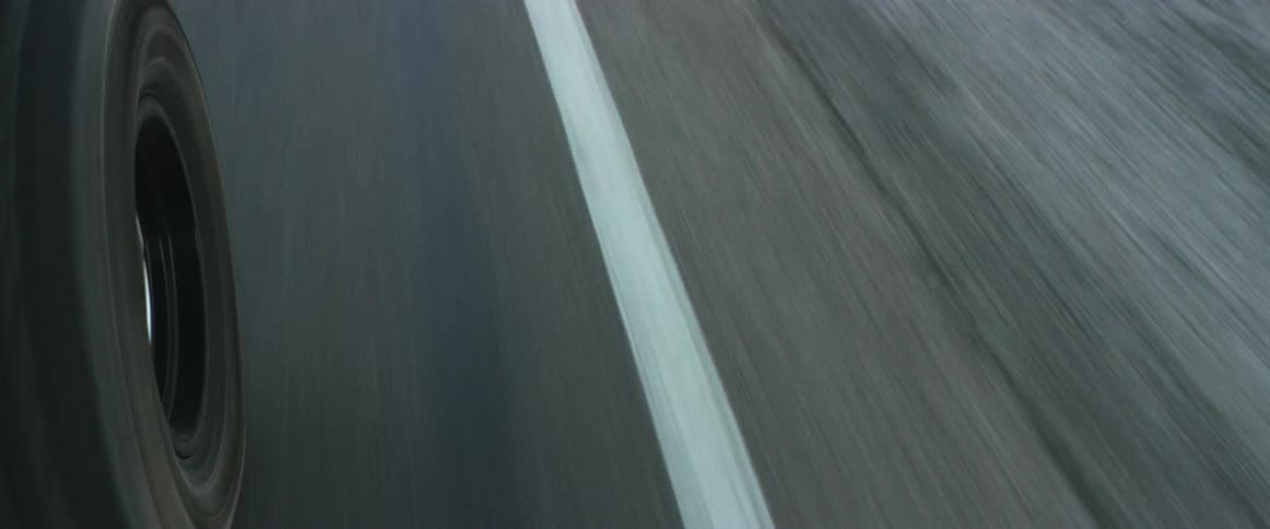 Wheel of a moving vehicle driving on an asphalt road