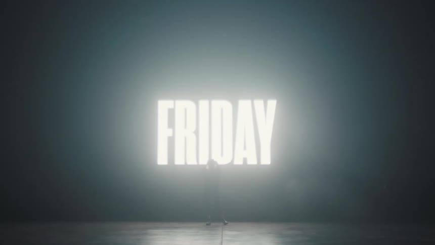 Silhouette of a woman standing in front of a dark back drop where the words black friday flash up and down