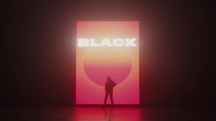 Silhouette of a woman modeling in front of a colorful black friday sign projected on the wall of a smoky dark room